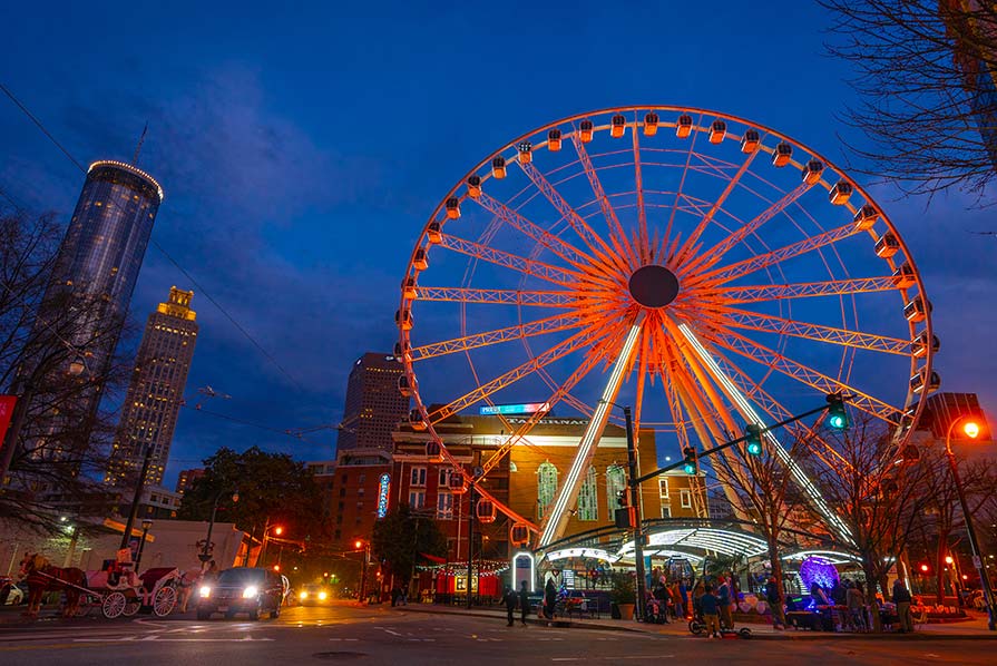 Wide shot of the SkyView Ferris wheel illuminated with orange light.