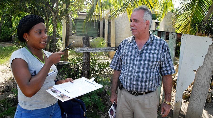 Ani Esther Rapsant, a medicator known to everyone as Lula, discusses drug administration for lymphatic filariasis at a “batey,” or farmworker village, with Dr. Manuel Gonzales of the Dominican Republic’s federal ministry of health. (Photo: The Carter Center) 