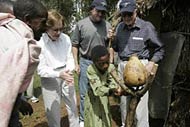 Former first lady Rosalynn Carter, philanthropist John Moores and former President Jimmy Carter watch as Sefeleg Balew, 10, demonstrates washing her hands after using the family's latrine in the village of Mosebo.