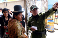 A policeman shows an Aymara woman where to vote.
