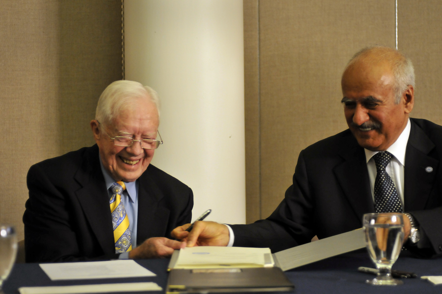 Suleiman Jasir Al-Herbish (right) and Jimmy Carter sign agreement.