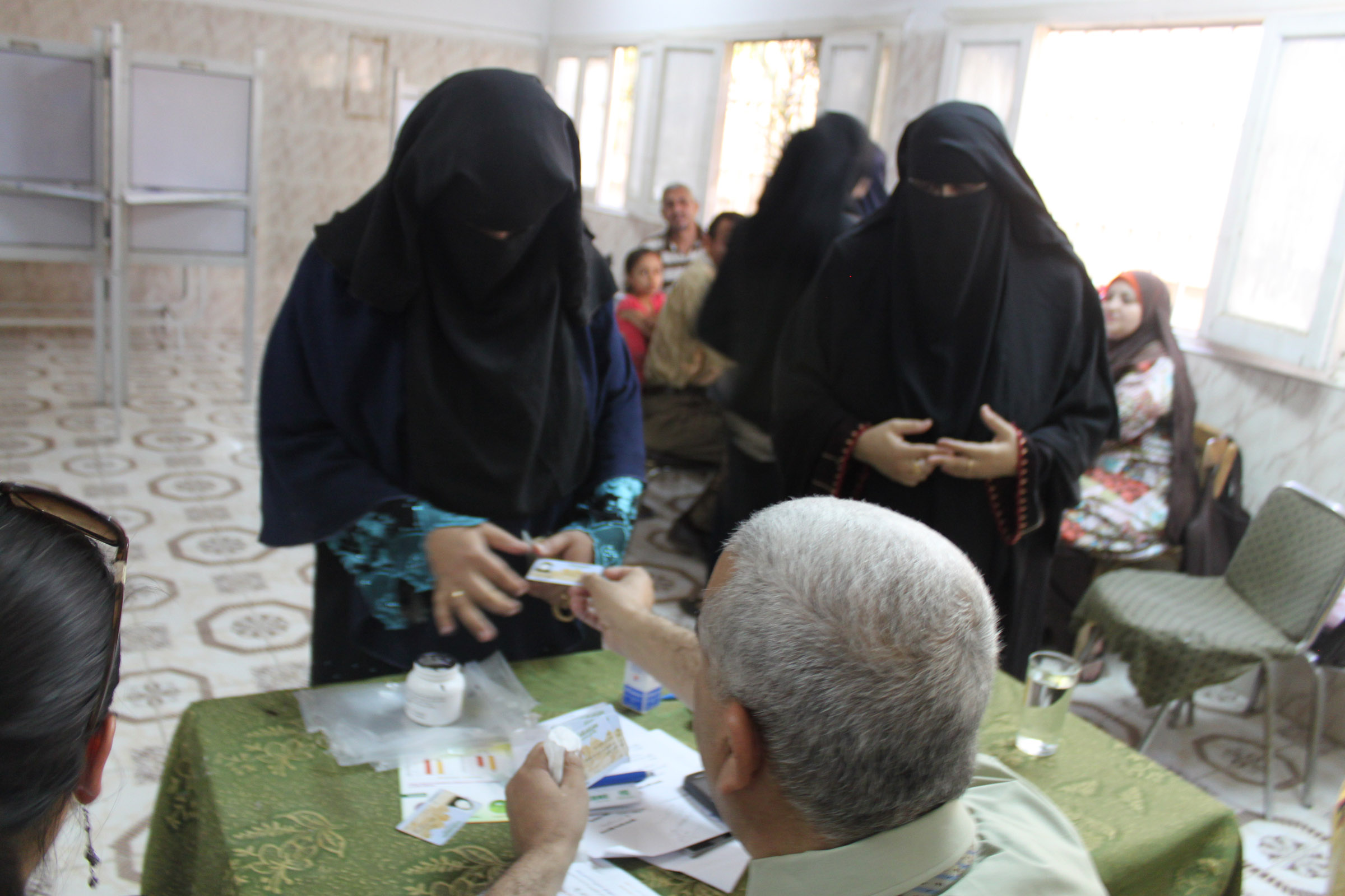 A judge checks the I.D. card of a voter at Aisha Hasaneen Primary School in Fayoum.