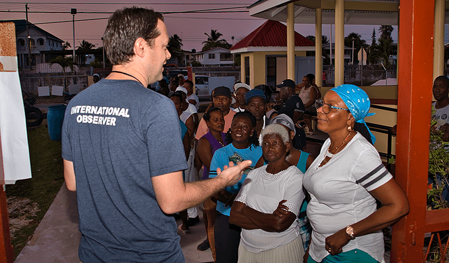 Jason Carter, chairman of The Carter Center Board of Trustees and co-leader of the Center’s election observation mission in Guyana, speaks with voters early in the morning on election day. (Photo: The Carter Center/R. Borden)