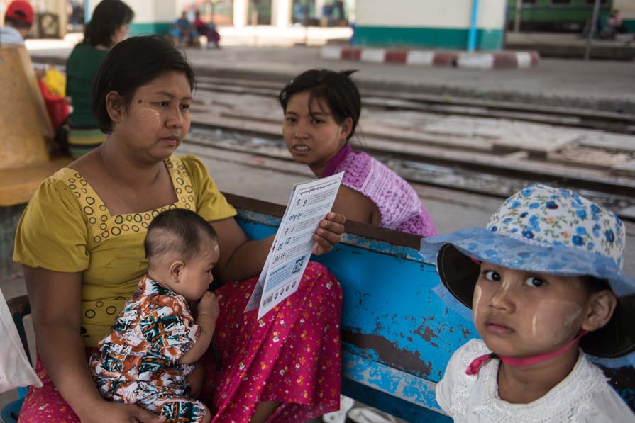 Woman and three children at a train station.