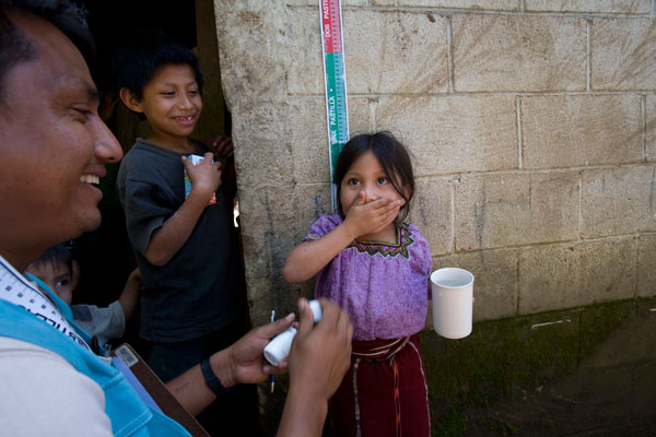 A health worker provides Mectizan to a young girl.
