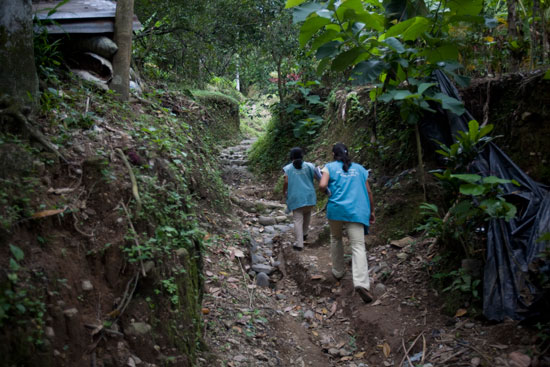 Two health workers walk through the Guatemalan jungle.