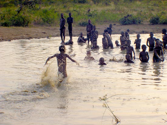 Children swim in a shallow pond in Nigeria.