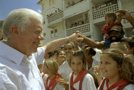Former U.S. President Jimmy Carter shakes the hands of eager schoolchildren during his historic trip to Cuba.