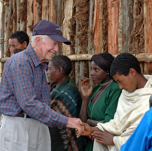Former U.S. President Jimmy Carter shakes hands with a young girl in Mosebo, Ethiopia.