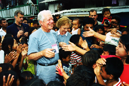 Former U.S. President Jimmy Carter and former First Lady Rosalynn Carter shaking hands with children during the Indonesian elections.