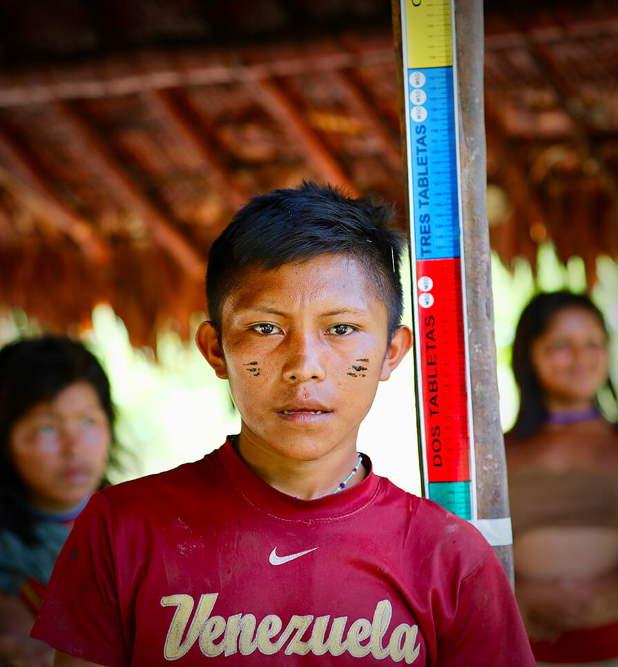 Yanomami boy being measured for correct medicinal dose