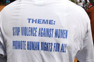 The back of a t-shirt reads Stop Violence Against Women, Promote Human Rights For All.