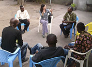 Valerie Hardin (top) joins a discussion with Father Gilbert Kalakumu and members of Church Saint Gonza.